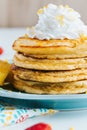 Closeup shot of a stack of healthy pancakes topped with whipped cream in a blue plate