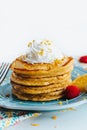Closeup shot of a stack of healthy pancakes topped with whipped cream in a blue plate