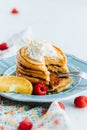 Closeup shot of a stack of healthy pancakes topped with whipped cream in a blue plate