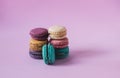 Closeup shot of stacks of colorful macarons on a pink background