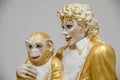 Closeup shot of a statue of Michael Jackson in golden costume and a monkey on his knees