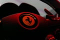 Closeup shot of a steering wheel of a Ferrari car under red lights