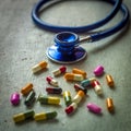 Closeup shot of stethoscope with a pile of antibiotic capsule pills