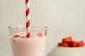 Closeup shot of strawberry milkshake with straw and bowl of strawberries in the background Royalty Free Stock Photo