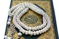 Closeup shot of a striped Islamic rosary on a holy Quran book Royalty Free Stock Photo