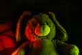 Closeup shot of a stuffed rabbit plush under colorful neon lights