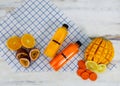 Closeup shot of summer tropical cold drink mixed juice bottle with sliced raw ripe fresh fruits mango orange lemon and passion Royalty Free Stock Photo