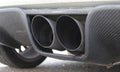 Closeup shot of a tailpipe of a car parked at a street