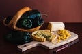 Closeup shot of tart, cheese and corn on the chopping board and green peppers in the wooden plate