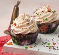 Closeup shot of tasty cupcakes decorated with colorful sprinkles against a pink background Royalty Free Stock Photo