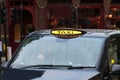 Closeup shot of a taxi driving in the street in London, England