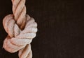 Closeup shot of a thick brown rope in a knot on a background with space for text