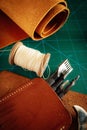 Closeup shot of thick leather sheets and tools for leathercraft on the table