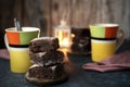 Closeup shot of three brownie pieces stacked on each other with teacups in the background Royalty Free Stock Photo