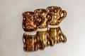 Closeup shot of three glazed clay cups put on a reflective surface Royalty Free Stock Photo