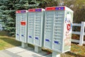 Closeup shot of three post mailboxes placed on the side of a street in Ottawa, Canada