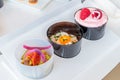 Closeup shot of three small bowls with different types of food on a white surface