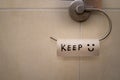 Closeup shot of a toilet paper hanger with the empty roll and written word Keep and a smiley Royalty Free Stock Photo