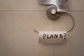 Closeup shot of a toilet paper hanger with the empty roll and written word Plan B Royalty Free Stock Photo