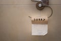 Closeup shot of a toilet paper hanger with the empty roll and written word Sorry Royalty Free Stock Photo