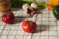 Closeup shot of tomatoes, garlic, baby carrots, bell peppers, and wooden mortar and pestle Royalty Free Stock Photo