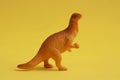 Closeup shot of a toy dinosaur miniature isolated on a yellow background