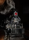 Closeup shot of a toy train with a locomotive steam engine against a dark background Royalty Free Stock Photo