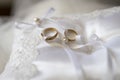 Closeup shot of the two beautiful golden wedding rings on a white fabric Royalty Free Stock Photo