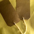 Closeup shot of two brown kraft tags on a black surface Royalty Free Stock Photo