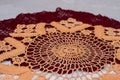 Closeup shot of two crochet doilies, one red and one cream-colored, on a white surface Royalty Free Stock Photo
