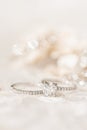 A closeup shot of two diamond wedding rings on a white surface Royalty Free Stock Photo