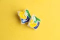 Closeup shot of the two dishwasher tablets on a yellow background