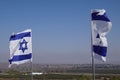 Closeup shot of two flags of Israel waving in the wind against the blue sky