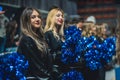 Closeup shot of two girls college cheerleaders with shiny blue pompons