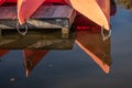 Closeup shot of two orange kayaks relfecting on the lake