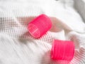 Closeup shot of two vibrant pink hair rollers on a white cloth Royalty Free Stock Photo