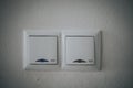 Closeup shot of two white light switches on a white wall Royalty Free Stock Photo