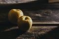 Closeup shot of the two yellow apples under the sunlight isolated on a wooden surface Royalty Free Stock Photo