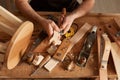 Closeup shot of unrecognizable faceless man carpenter making a handmade wooden toy in a home workshop, working on table among Royalty Free Stock Photo