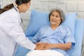 Closeup shot of unrecognizable unknown doctor in white lab coat with stethoscope hand holding comforting supporting old senior Royalty Free Stock Photo