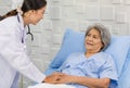 Closeup shot of unrecognizable unknown doctor in white lab coat with stethoscope hand holding comforting supporting old senior Royalty Free Stock Photo