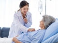 Closeup shot of unrecognizable unknown doctor in white lab coat with stethoscope hand holding comforting supporting old senior Royalty Free Stock Photo