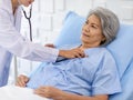 Closeup shot of unrecognizable unknown doctor in white lab coat with stethoscope hand holding comforting supporting old senior Royalty Free Stock Photo