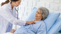 Closeup shot of unrecognizable unknown doctor in white lab coat with stethoscope hand holding comforting supporting old senior Royalty Free Stock Photo