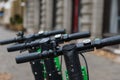 Closeup shot of the upper part of electric scooters parked on a street in a city