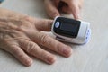 Closeup shot using finger pulse oximeter to check oxygen saturation and heart rate of a person tracking coronavirus symptoms -