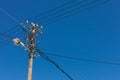 Closeup shot of a utility pole transmission wires under a blue clear sky