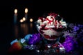 Closeup shot of vanilla ice cream with multiple fruits and a glass bowl next to a strawberry