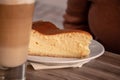 Closeup shot of a vanilla pie and a glass of latte on a wooden table Royalty Free Stock Photo