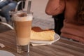 Closeup shot of a vanilla pie and a glass of latte on a wooden table Royalty Free Stock Photo